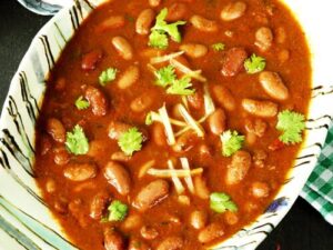 A bowl of creamy and spiced rajma masala garnished with coriander.(मसालेदार और क्रीमी राजमा मसाला की कटोरी, हरे धनिये से सजी हुई|